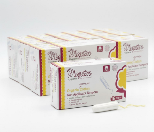 Maxim Hygiene organic cotton non-applicator tampons (16 regular) multi-pack boxes shown with a tampon and yellow string, highlighting chlorine-free, hypoallergenic period protection with reduced-waste packaging.