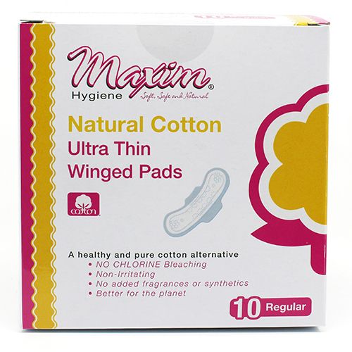 Front of a Maxim Hygiene pack labeled “Natural Cotton Ultra Thin Winged Pads,” featuring a small pad illustration, cotton logo, claims like no chlorine bleaching and no added fragrances, and “10 Regular” count on a white-and-pink box.